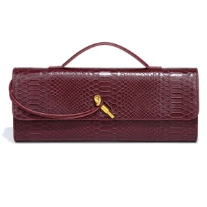Vinröd kuvertväska i skinn - (Finns även 6 olika färger:)Snygg vinröd kuvertväska med reptilmönster och guldfärgad detalj på framsidan. Väskan har ett smidigt handtag upptill och är tillverkad i skinn med en lyxig finish. Perfekt för att lyfta din outfit med en cool och elegant touch.