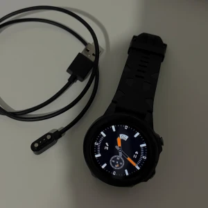 Elegant Smartklocka med Pulsmätare, Notiser & Sportlägen – Originalkvalitet - Snygg och robust smartklocka i originalkvalitet! Klockan har flera praktiska funktioner som hjälper dig i vardagen:  ✅ Pulsmätning i realtid ✅ Stegräknare och kaloriövervakning ✅ Flera sportlägen (löpning, cykling, promenad m.m.) ✅ Notiser från WhatsApp, Facebook, SMS och samtal ✅ Stoppur och timer ✅ Lång batteritid och magnetisk laddning  Klockan är i mycket bra skick och fungerar perfekt. Passar både för träning och vardagsbruk.  💪 Perfekt för dig som vill hålla koll på hälsan och vara uppkopp