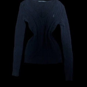 Mörkblå stickad pullover från Ralph Lauren - Mörkblå stickad tröja från Ralph Lauren med klassiskt kabelstickat mönster och v-ringad hals. Storlek M men passar absolut S också!!, jag har s och den passar mig jätte bra. Bilder kan skickas Super bra skick, inga defekter ❤️ skicka gärna pris förslag om det är så att ni inte vill köpa för det fasta priset☺️
