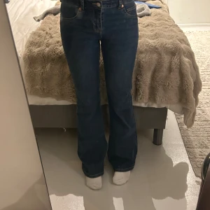 Blå bootcut jeans med rå kant - Nästan helt nya men kommer ej till användning. Säljer ett par blå bootcut jeans med mid midja och rå, fransad kant nertill. Klassisk femficksmodell i jeansmaterial, perfekt för dig som gillar en avslappnad och trendig look. Snygg passform och sköna att bära hela dagen. Lite sönder där nere som ni kan se på bilden men absolut inte alls mycket och inget man tänker på alls. Ny pris 400. Passar xs och S. 🥰🥰