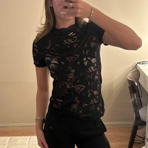 Spetstopp - Jättesnygg svart spetstshirt. Tror den är från noa noa men ör osäker då lappen är avklipps. Tror den är i strl XS/S. Mycket bra skick.