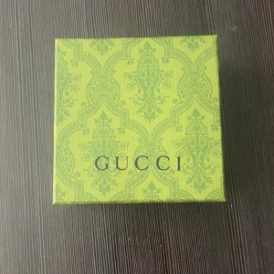 Svart Gucci bälte med GG-spänne - Säljer ett svart Gucci bälte med klassiskt GG-mönster och en stor, silverfärgad GG-logga som spänne. Bältet är gjort i skinn och har en stilren design som lyfter vilken outfit som helst. Kommer i originalförpackning.