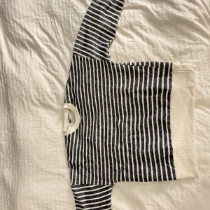 Randig stickad tröja från Zara - Säljer en snygg stickad tröja från Zara i storlek M. Tröjan är vit och grå med smala ränder, har rund hals och långa ärmar. Perfekt för lager på lager under höst. Aldrig använd, skickar samma dag som betalning, mer bilder kan lösas Mvh!