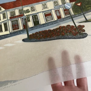 Richard Carlsson Original Färgträsnitt 126/276 – Signerat & Limiterat - Unikt originalfärgträsnitt av svenska konstnären Richard Carlsson. Handsignerat och numrerat 126/276. Charmig svensk stadsmiljö i klar träsnittsteknik med vacker färgpalett. Perfekt för samlare och som unik inredningsdetalj. Skickas väl förpackat.