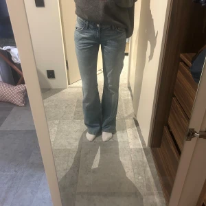  bootcut jeans ljusblå - Säljer ett par  jeans i ljusblå tvätt. De har bootcut-modell med lätt utsvängda ben och normal passform. Jeansen har fem fickor, knappgylf och är tillverkade i slitstarkt denim. Perfekta för en avslappnad och cool look.