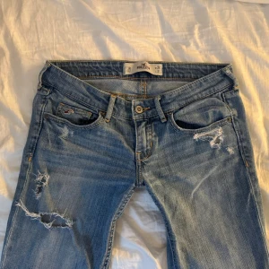 Lågmidjade jeans - Jätte snygga omsydda lågmidjade jeans från Hollister! De är förstärkta, se bild, och omsydda vid benen! Storlek: W26 L31. Skriv om ni vill ha fler eller tydligare bilder på det omsydda eller förstärkta! Midjemått: ca 37cm Innerbenslängd: ca 78cm! 💕 Jag kan ofta posta samma dag och priset kan diskuteras!