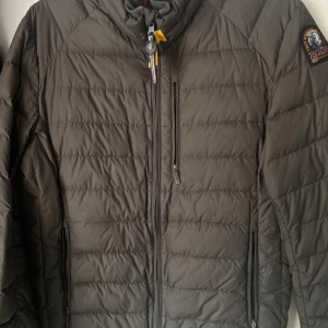 Parajumpers höstjacka - Säljer en dunjacka från Parajumpers i storlek S. Jackan är superlätt, har horisontella sömmar, dragkedja framtill och flera fickor med dragkedja. Klassisk patch på ärmen och snygga detaljer vid kragen. Perfekt för kalla dagar när du vill hålla stilen.