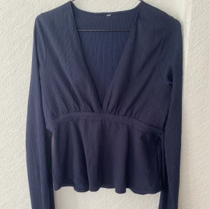 Långärmad knyt topp  - Säljer en marinblå knyt topp från Nelly i storlek L, den har fått lite vit ull på sig från min jacka men det går nog bort i tvätten, ett litet hål (kolla bild 3) men det är inget som är synligt över huvud taget! Säljer den för 60kr + frakt!