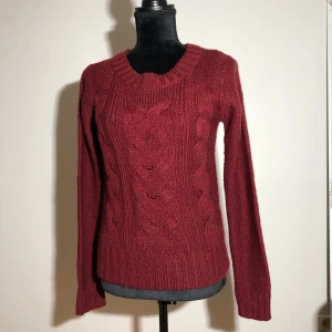 Vinröd stickad ulltröja - Tröja med 20% ull. Ärmlängd ca 70cm. Längd ca 60cm. Pris: 30kr 