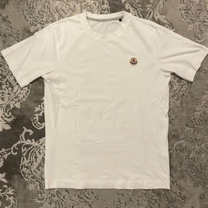 Moncler T-shirt  - Snygg stilren oanvänd Moncler t-shirt med klassisk passform och rund hals. Perfekt till alla tillfällen jeans eller shorts för en clean klass look, pris kan diskuteras vid snabb affär.