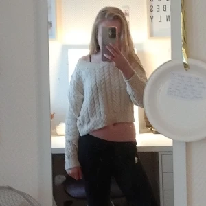 Beige stickad tröja Lindex - Superfin beige croppad stickad tröja från Lindex med flätstickat mönster och bred ribbad kant. Tröjan har lång ärm och en lite lösare passform med offshoulder-vibe. Perfekt för lager-på-lager och chill stil.