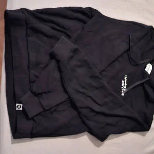Svart hoodie med tryck och huva - Svart hoodie med vit text på bröstet som säger 'Listening is everything'. Tröjan har huva med snören och långa ärmar. Mjuk och skön, perfekt för chill dagar eller när du vill ha en enkel streetstyle-look. Aldrig använd!