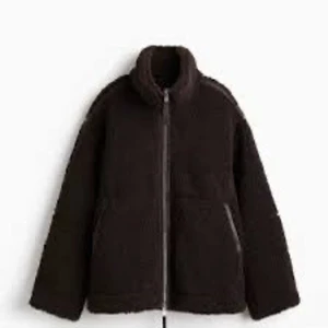 Mörkbrun teddyjacka H&M - Mysig mörkbrun teddyjacka med hög krage och hel dragkedja framtill. Jackan har två sidofickor och en avslappnad passform. Från H&M helt slutsåld i alla storlekar.