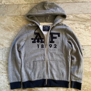 Abercrombie and Fitch kofta - Vintage Abercrombie and Fitch zip i fint skick! St S! Mått: längd- 65cm, bredd- 53cm! Hör av dig vid ytterligare frågor! Mvh Henry 