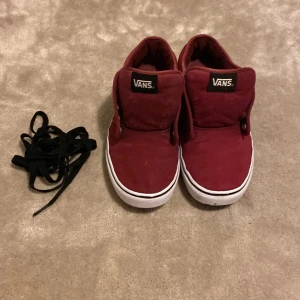 Vinröda Vans sneakers EU 42.5 - Säljer ett par vinröda Vans sneakers i textil med klassisk vit sula och svart Vans-logga på plösen och hälen. Skorna har rund tå, platt sula och kommer med svarta skosnören. Är öppen för ett lägre pris vid snabb affär. Om ni har några frågor skriv gärna!