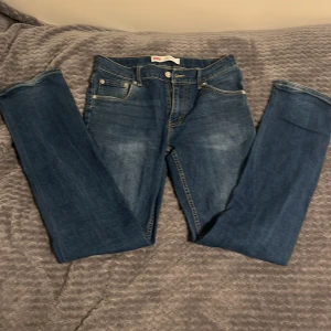 Levi's 511 Slim jeans blå st 176 cm - Snygga Levi's 511 Slim jeans i klassisk blå färg med lätt slitning framtill. Modellen har fem fickor, gul kontrastsöm och en slim passform som sitter schysst på benen. Perfekt för dig som gillar en modern och stilren look.