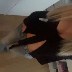 Svart omlottopp med knyt - Från Gina,knappt använd men lite knopprig för den blir lätt det