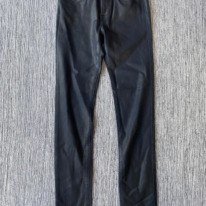 Svarta skinny jeans Jacob Cohën - Snygga svarta skinny jeans från Jacob Cohën med exklusiv italiensk design. Byxorna har klassisk femficksmodell, smal passform och är tillverkade av en mix av viskos, bomull och lyocell för en mjuk och stretchig känsla. Perfekt för dig som gillar stilrena och lyxiga jeans. Mått Midjan: ca 34 cm Längd från grenen och ner: ca 76 cm  43% viskos, 33% bomull, 17% lyocell,  5% polyester och 2% elastan.  Kommer från ett djur och rökfritt hem.