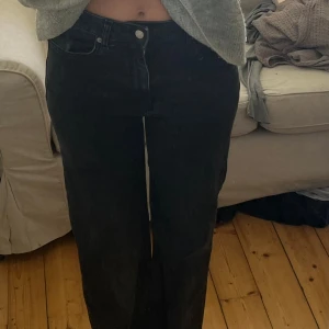 Svarta wide jeans med medel låg midja - Säljer ett par svarta jeans med hög midja och wide fit. Byxorna har klassisk femficksdesign och raka, vida ben. Perfekta för dig som gillar en avslappnad och trendig look. Materialet är jeans och färgen är svart.