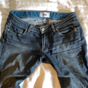 Mörkblå jeans från Paige - snygga mörkblå bootcut jeans från Paige som är väl använda men ser fof jättebra ut på! 
