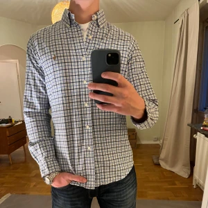 Rutig Ralph Lauren skjorta vit blå  - Säljer denna sjukt snygga skjortan från Ralph Lauren⭐️ Färgen är rutig blå vit och storleken är M✅ Den har inga defekter och skicket är utomordentligt🙌🤝 Sjukt najs passform och passar perfekt till hösten🍁🙌 Tveka inte på att höra av er dig vid minsta fråga eller fundering😊