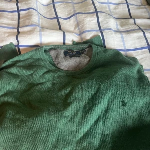 Grön tröja från Polo Ralph Lauren XXL - Snygg grön tröja från Polo Ralph Lauren i storlek XXL. Tillverkad i mjuk pima bomull med rund hals och diskret broderad logga på bröstet. Perfekt för dig som gillar klassisk stil med en modern touch.