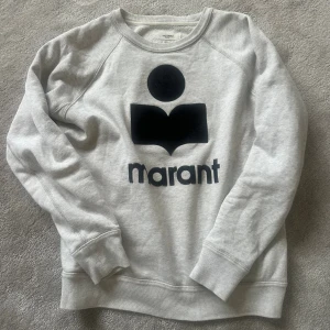 Grå sweatshirt Isabel Marant Étoile - Snygg grå sweatshirt från Isabel Marant Étoile med svart logga framtill. Tröjan har rund halsringning, långa ärmar och är tillverkad i mjuk bomull. Perfekt för en chill och trendig look. Använd max 8-10 ggr så i fint skick! 