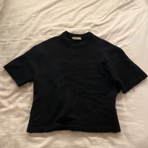 Svart stickad tröja från Gina Tricot - En svart stickad tröja från Gina Tricot med kort ärm och rund halsringning. Storlek S💕