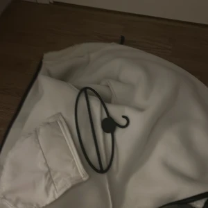 Vit fleecekjol med ficka - Säljer en vit fleecekjol med en praktisk ficka framtill. Kjolen har en mjuk och varm känsla, perfekt för kyliga dagar. Enkel design med svarta detaljer längs kanten som ger en snygg kontrast. Passar dig som gillar bekväma och stilrena plagg.