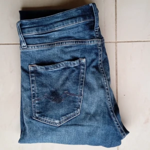 Replay Thad - Säljer ett par klassiska blå jeansbyxor från Replay med raka ben och femficksdesign. Jeansen har normal passform och är tillverkade i slitstarkt denimtyg. Perfekta för en avslappnad stil. Passar 160 - 175. Nypris: 800. Pris är diskuterbart