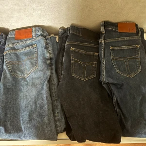 Tre tiger of Sweden jeans  - Säljer tre par klassiska jeans i olika tvättar – ett par ljusblå, ett par svarta och ett par mörkblå. Alla har raka ben, kontrastsömmar och klassiska bakfickor med dekorativa sömmar. Perfekta för dig som gillar tidlös denimstil. Du får alltså alla 3 par jeans för 350