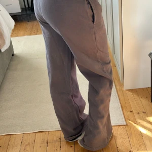 Bruna mjukisbyxor med resårmidja - Säljer ett par bruna mjukisbyxor med resår i midjan och raka, lite vidare ben. Byxorna har fickor på sidorna och är gjorda i mjukt bomullsmaterial. Perfekta för en chill och avslappnad stil.