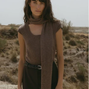 Stickad topp i ull med scarf-detalj - Helt oanvänd supersnygg brun stickad topp som passar perfekt till hösten. Den har en djup u-ringning och en fastsittande scarfdetalj. Toppen är i 100% ull och har prislappen kvar⭐️nypris: 699 kr 