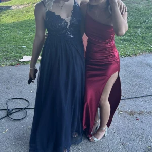 Balklänning - Säljer nu min fina mörkblåa klänning från JJ’s House. Den är dekorerad med paljetter, har djup v-ringning och är öppen i ryggen. Klänningen är gjord efter kroppsmått men skulle säga att det är storlek S