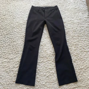 Kostymbyxor lågmidjade - Säljer dessa populära kostymbyxor från Bikbok! De är lågmidjade och bootcut. Säljer då de är för små tyvärr.  Innerbenslängden - 79cm Midjemåttet - 36 cm tvärs över 