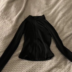 Svart långärmad ziptröja från SHEIN - Svart långärmad tröja från SHEIN i storlek XS. Tröjan har hel dragkedja framtill, snatchar din midja!! 