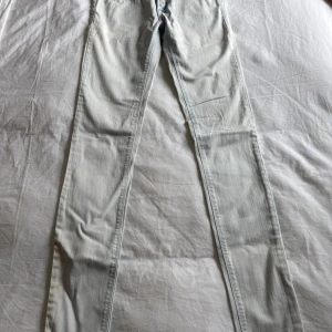 Jeans - Säljer ett par ljusblå jeansbyxor från Replay med klassisk femficksdesign och silverfärgad logga bak i midjan. Byxorna har raka ben och diskreta sömmar, perfekta för en stilren look.