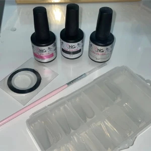 Nagelkit  - Nagelkit med tre gel polish från NagelGiganten i olika nyanser:            -svart, nude pink och vit.                   -pensel för nageldesign.                          -vitt & svart striping tejp (1mm tjock) -transparenta lösnaglar i Coffin form.                            