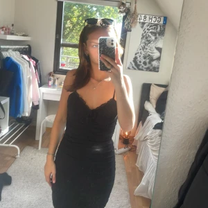 Svart kort klänning från H&M Divided - Supersnygg svart kort klänning från H&M Divided med smala axelband och lätt rynkade detaljer framtill. 