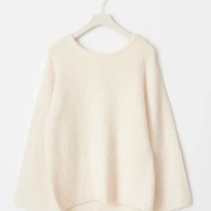 Stickad tröja med rosett och öppen rygg - Supersöt stickad tröja i både vitt och svart med rund hals, lång ärm och öppen rygg som knyts med en bred rosett. Tröjan har en loose fit och är perfekt för lager-på-lager. Mjuk och mysig känsla, passar till jeans eller kjol.