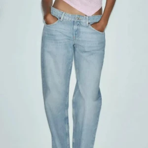 Zara jeans - Säljer ett par ljusblå jeans med rak passform och klassisk femficksdesign. Jeansen har normal midja och är tillverkade i mjukt denimtyg som ger en avslappnad vibe. Perfekta för dig som gillar en enkel och stilren look.