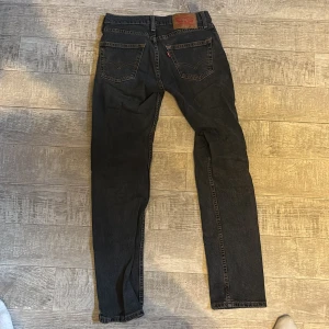 Mörk blås Levi's 511 jeans  - Svarta Levi's 511 jeans med klassisk femficksdesign och smal passform. Jeansen har en mörk tvätt, raka ben och detaljer som nitar och Levi's patch bak. Perfekt för dig som gillar en clean och stilren look.