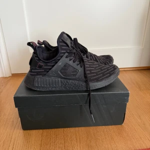 Adidas NMD XR1 PK  - Svarta Adidas NMD XR1 PK sneakers med stickad ovandel och mönstrad design. Skorna har svarta snören, svart boostsula. Inga hål eller fläckar, endast att lite färg har lossnat på kanten av boosten.