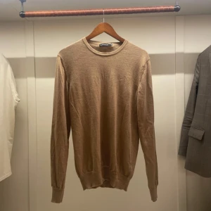 J.lindeberg Stickad tröja - Skit snygg tröja från J Lindeberg, perfekt till hösten med en ganska vintage look och som är sandfärgad Ny pris på denna är 1300kr mitt är 499 kr hör av er om ni är intresserade!