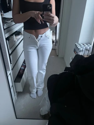 Vita low waist straight jeans - Säljer ett par vita jeans med låg midja och raka ben. Modellen är straight och har klassisk femficksdesign med dragkedja och knapp framtill. Materialet är jeans och passformen är normal. Perfekt för dig som gillar clean och enkel stil.