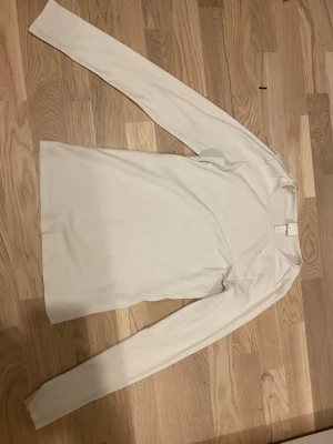 Vit långärmad tröja - Säljer denna ribbade, långärmade, vita tröja från H&M i strlk S. Tröjan är i mycket bra skick. Kontakta mig vid frågor🥰