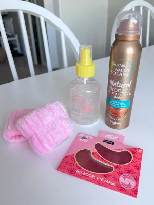 Spa-kit med bronzing mist, eye pads mm - Ett spa-kit / hudvårds-kit. En Garnier Ambre Solaire Natural Bronzer i medium, en Budgie shimmer face mist, samt Sence hydrogel eye mask i rosa för fräsch glow. Medföljer även fluffiga rosa armband för sminkborttagning. Allt är oanvänt. Köper du innan kl 16:00 kan jag posta samma dag!