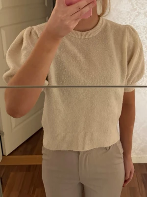 Beige stickad tröja med puffärm - Säljer en beige stickad tröja med korta puffärmar. Säljer pga att den inte kommer till användning. Tycker inte att den sticks eller är obekväm men det är ju självklart individuellt💕