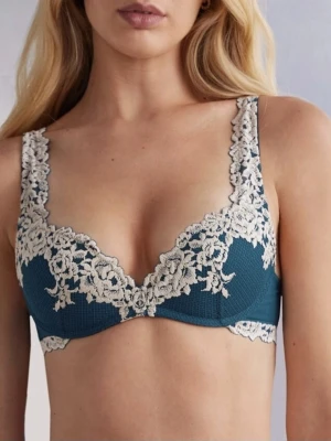 Intimissimi Bh!💙💚 - Säljer en snygg väst med blommig spetsdetalj i beige över en mörkblå botten. Västen har v-ringad form och breda axelband med spets som fortsätter längs kanten. Materialet är mjukt och har en elegant känsla, perfekt för att lyfta din outfit.