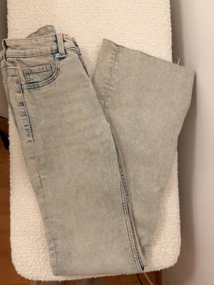 Ljusblå wide jeans från H&M Divided - Säljer ett par ljusblå jeans från H&M Divided i storlek 34. Modellen är wide med raka ben och klassisk femficksdesign. Jeansen har en snygg tvättad look och är tillverkade i bomullsmaterial. Perfekta för dig som gillar avslappnad stil.